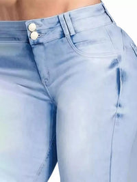 Light blue jeans with a button detail on a blurred background