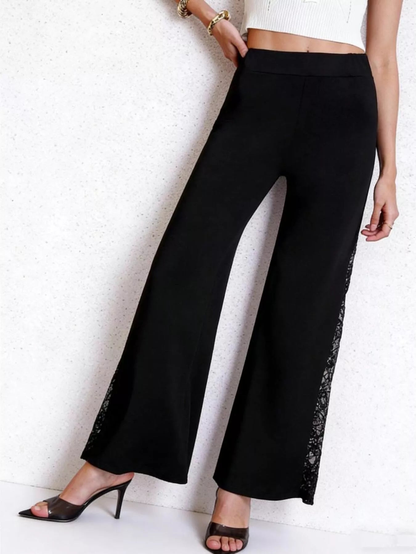 Black wide-leg pants with lace trim worn by a person on a white background
