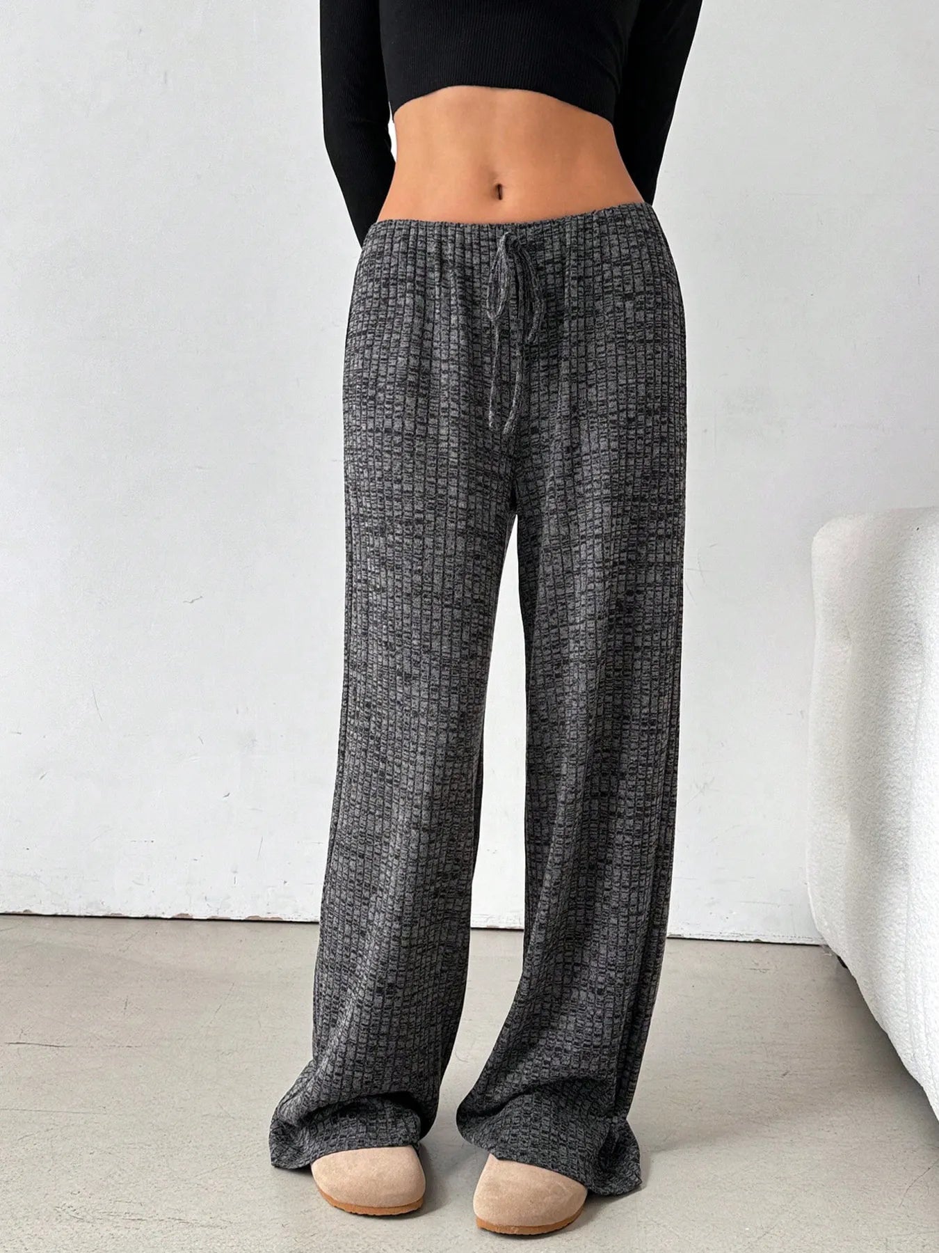 Person wearing gray checkered pants on a plain background