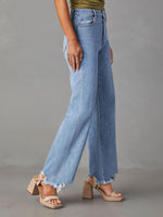 Light blue jeans worn by a person on a gray background
