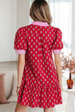 Woman wearing a red floral dress in a living room setting