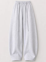 Light gray heather sweatpants with an elastic drawstring waist and wide legs, shown flat against a light beige background.