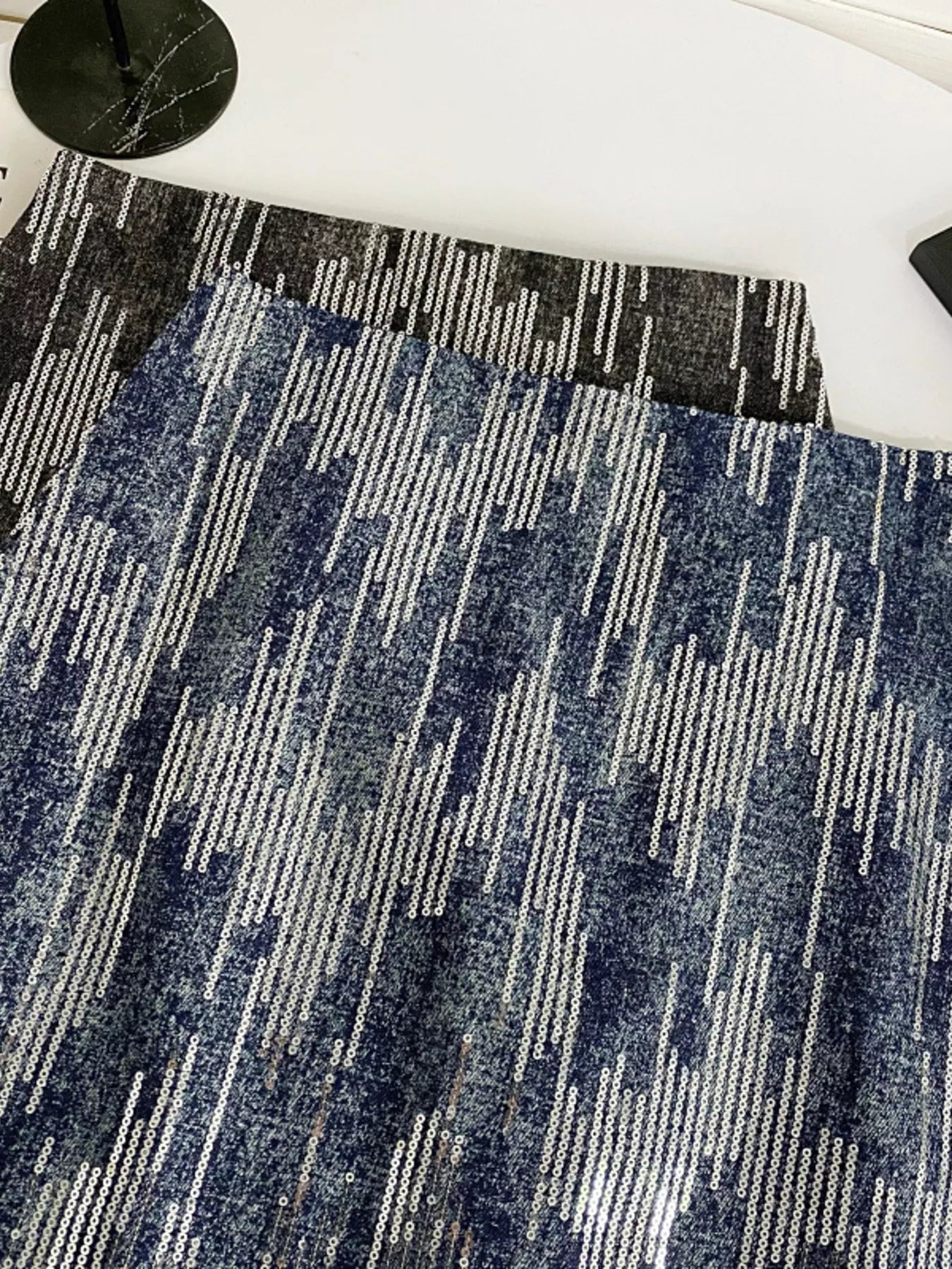 Close-up of a blue and gray patterned rug on a white floor.