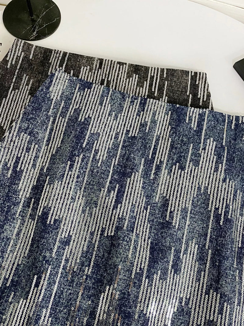 Close-up of a blue and gray patterned rug on a white floor.