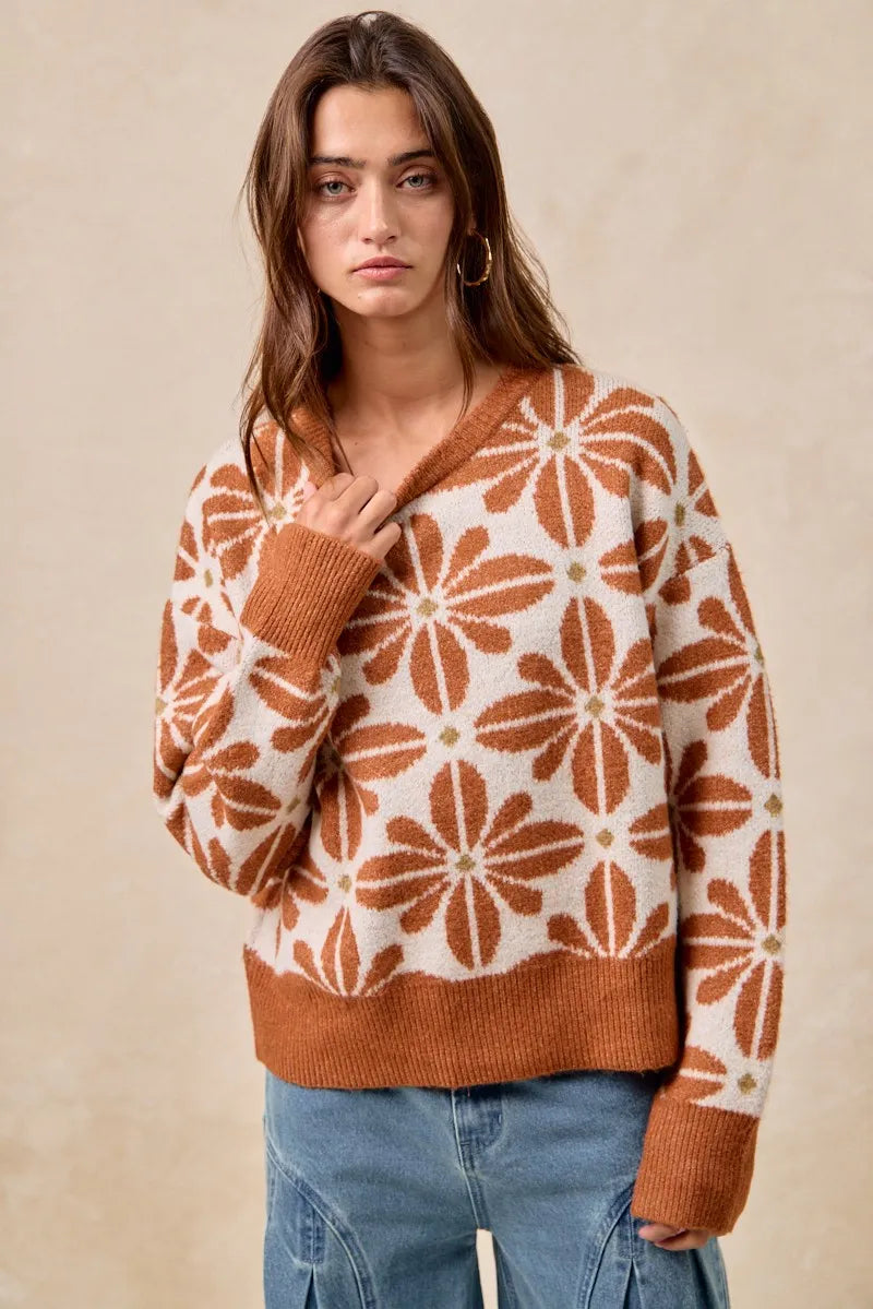 Woman wearing a brown and white patterned sweater against a beige background