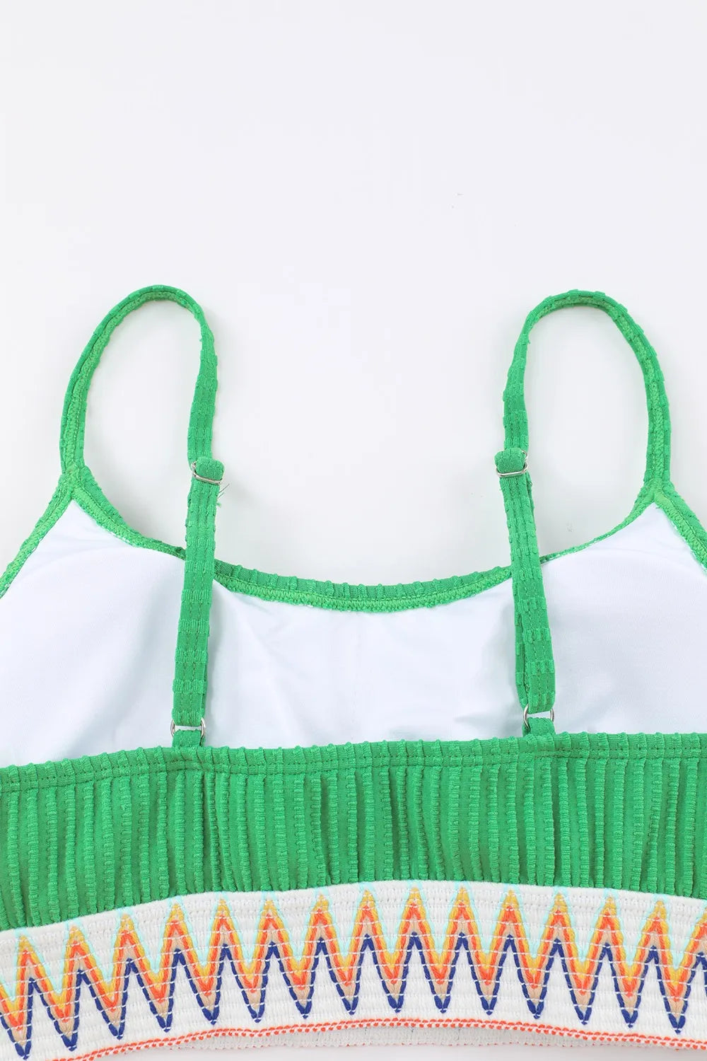 Green and white top with colorful zigzag pattern on a white background