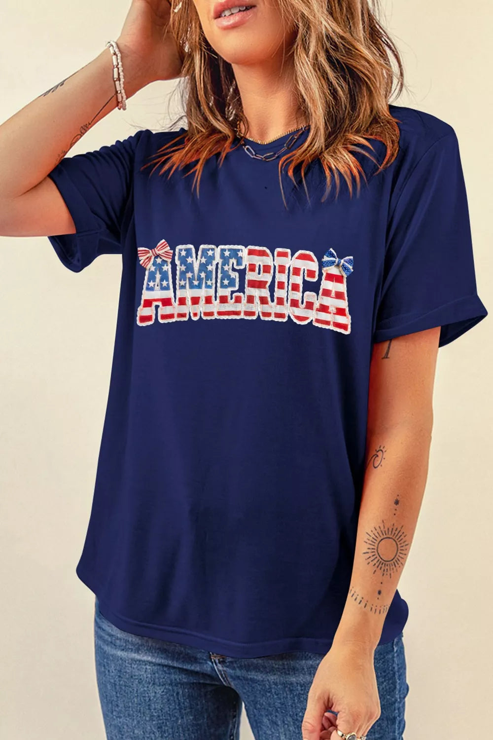 Person wearing a navy blue t-shirt with 'AMERICA' printed in red, white, and blue.