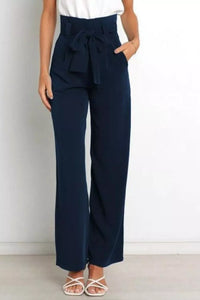 Navy wide-leg pants with a white top on a plain background