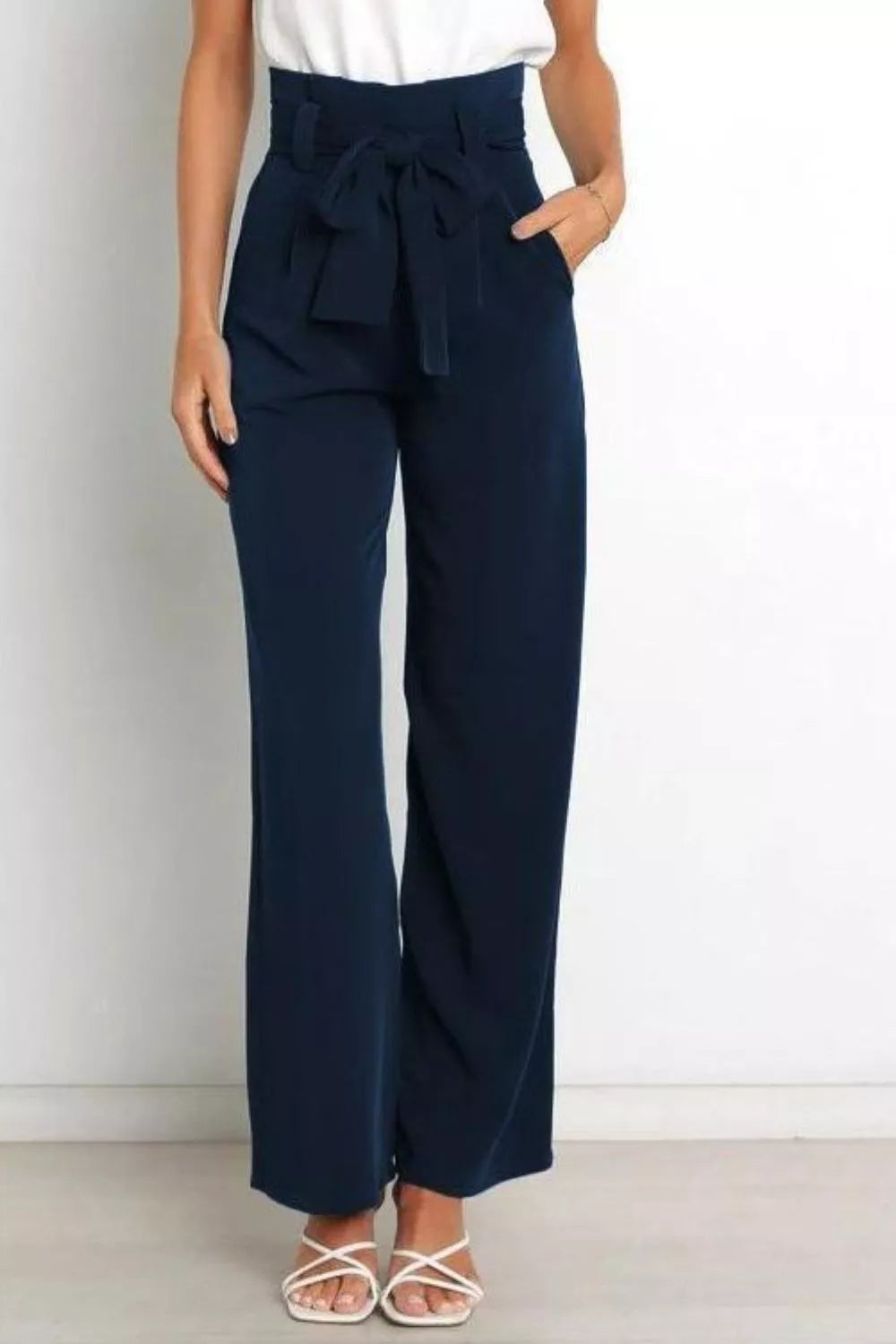 Navy wide-leg pants with a white top on a plain background