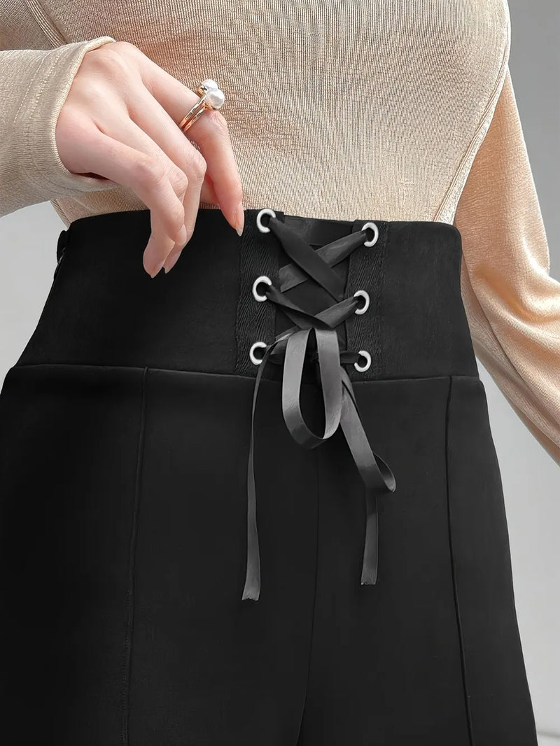 Black pants with lace-up design worn by a person, against a neutral background