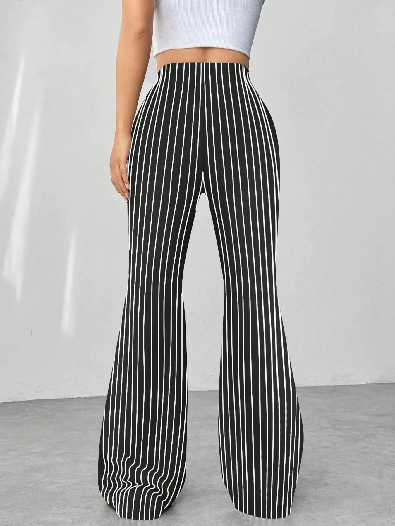 Black and white striped wide-leg pants worn by a person on a plain background