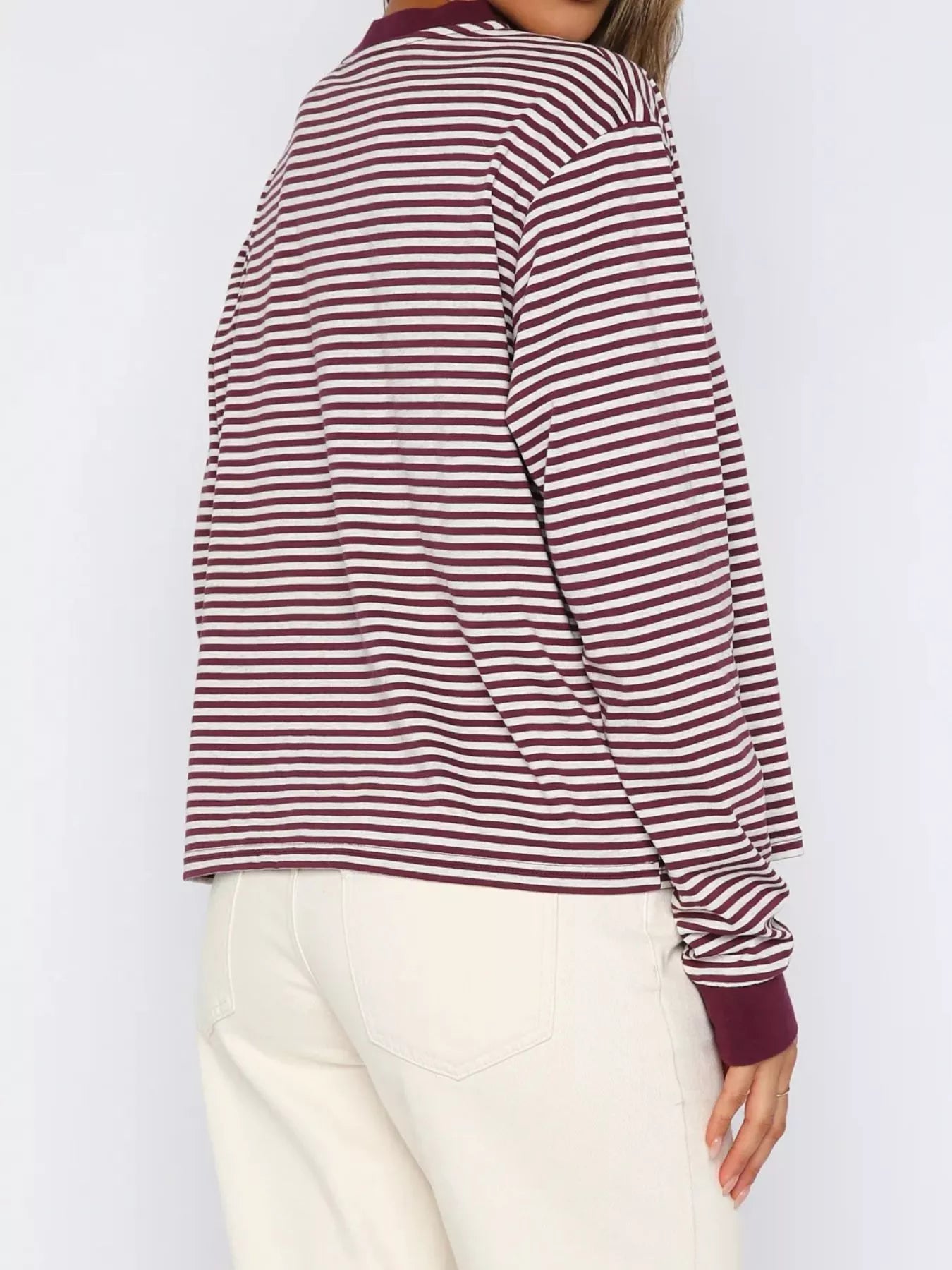 Person wearing a maroon and white striped long-sleeve shirt against a white background