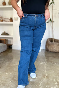 Person wearing blue jeans and a black top in an indoor setting
