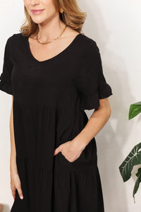Woman wearing a black dress with a plain background