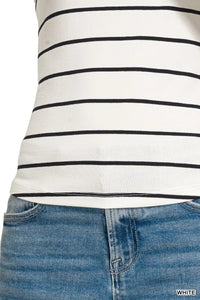Close-up of a person wearing a white tank top with black stripes and blue jeans.