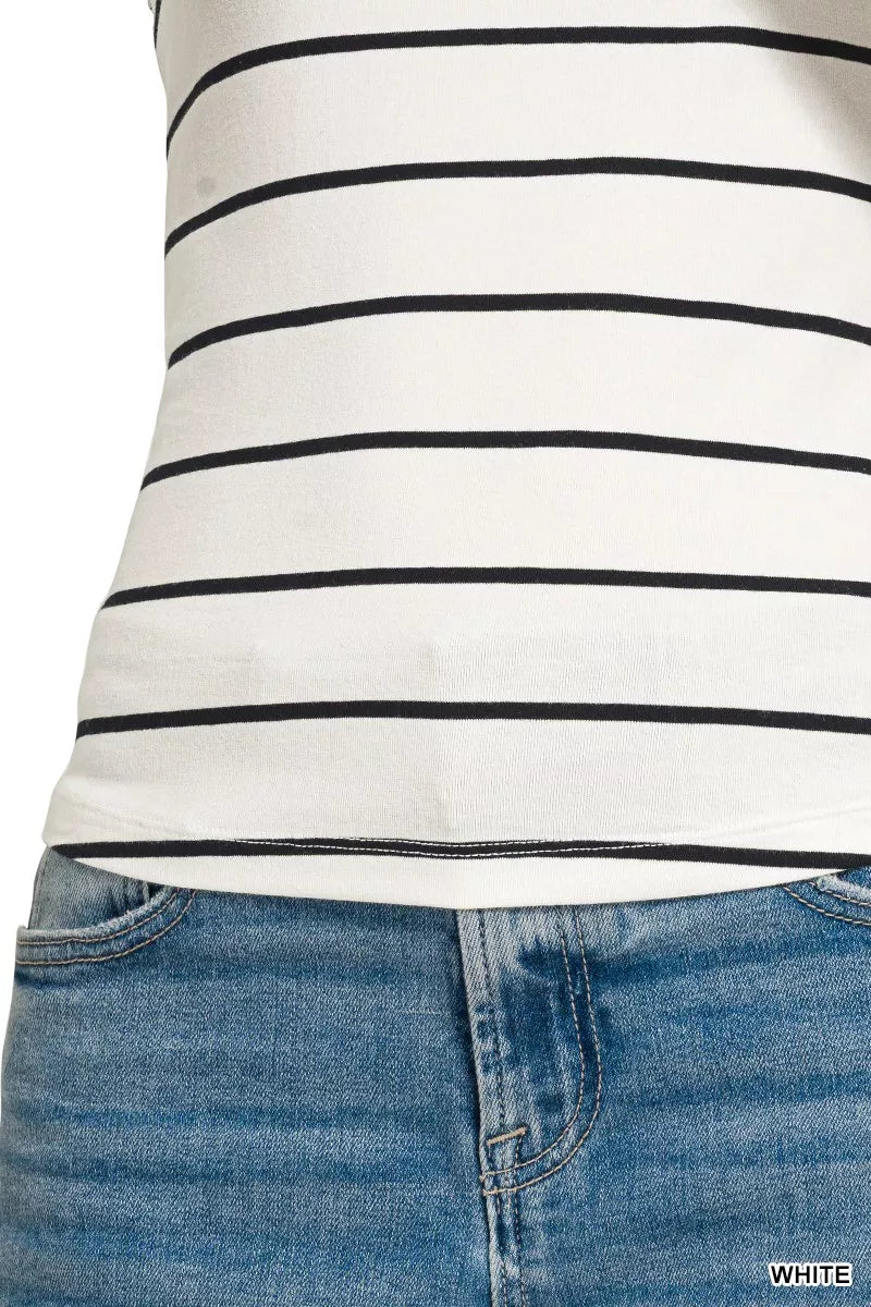 Close-up of a person wearing a white tank top with black stripes and blue jeans.