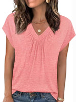Woman wearing a pink short-sleeve top and blue jeans on a white background