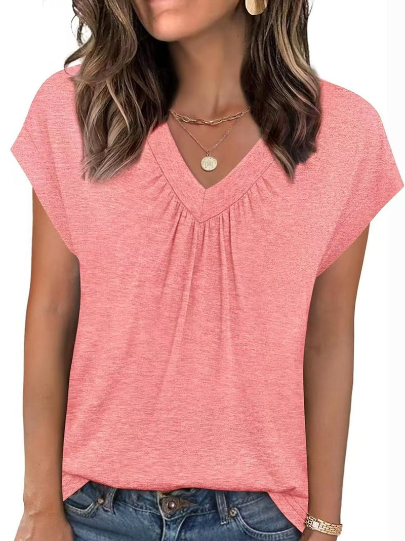 Woman wearing a pink short-sleeve top and blue jeans on a white background
