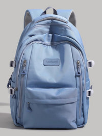 Light blue backpack with multiple zippers on a gray background