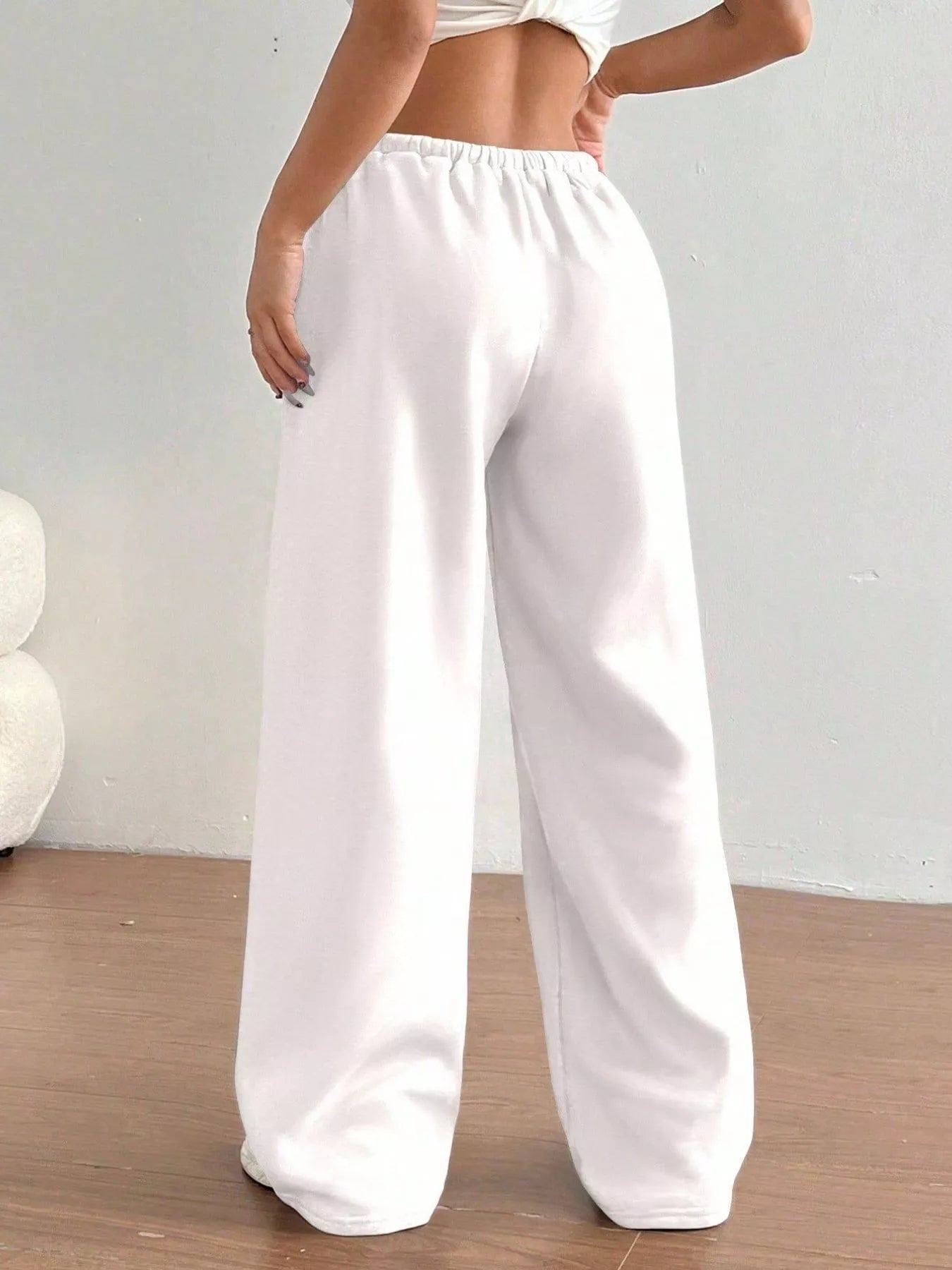 White wide-leg pants worn by a person on a plain background