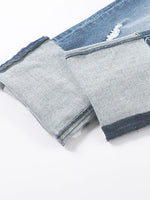Close-up of gray pants with blue denim trim on a white background