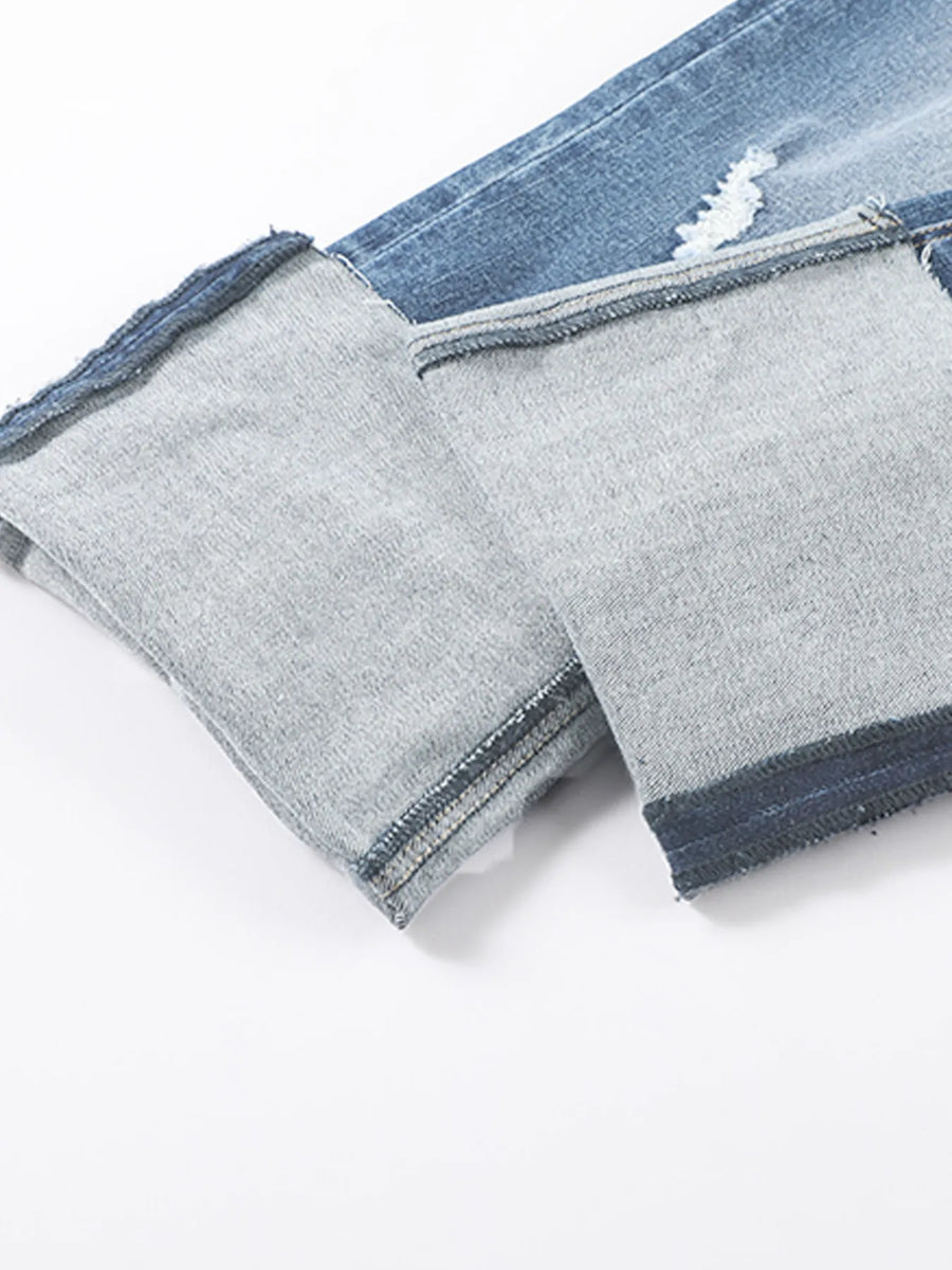 Close-up of gray pants with blue denim trim on a white background