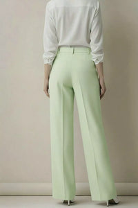 Person wearing a white shirt and light green pants against a plain background