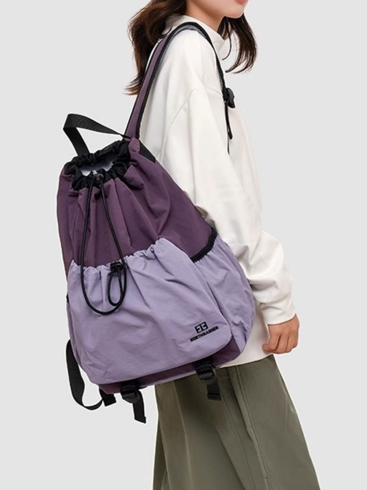 Person wearing a two-tone purple backpack on a plain background