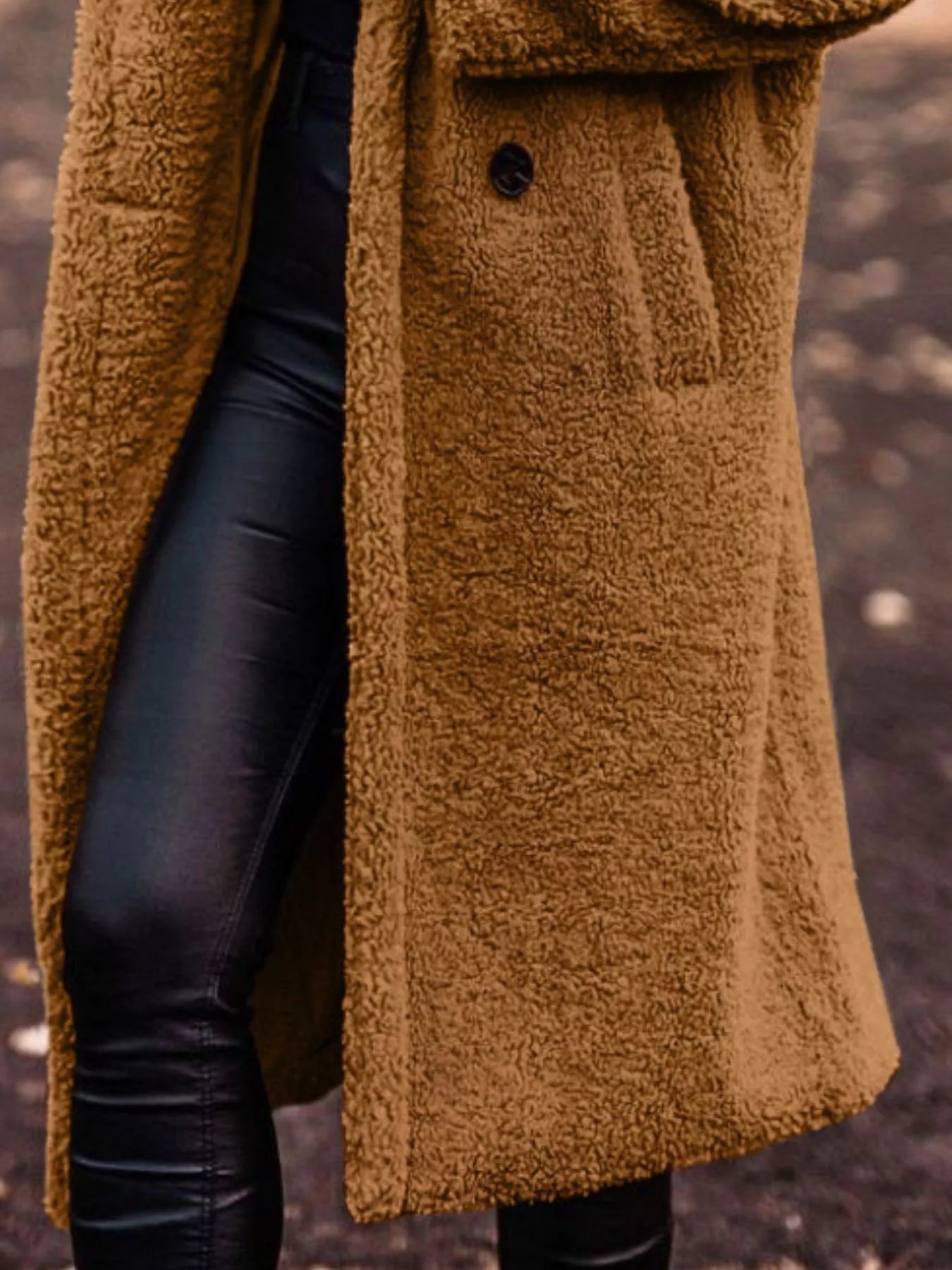 Brown teddy coat worn by a person with a blurred background