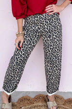 Person wearing leopard print pants and a red top against a white background