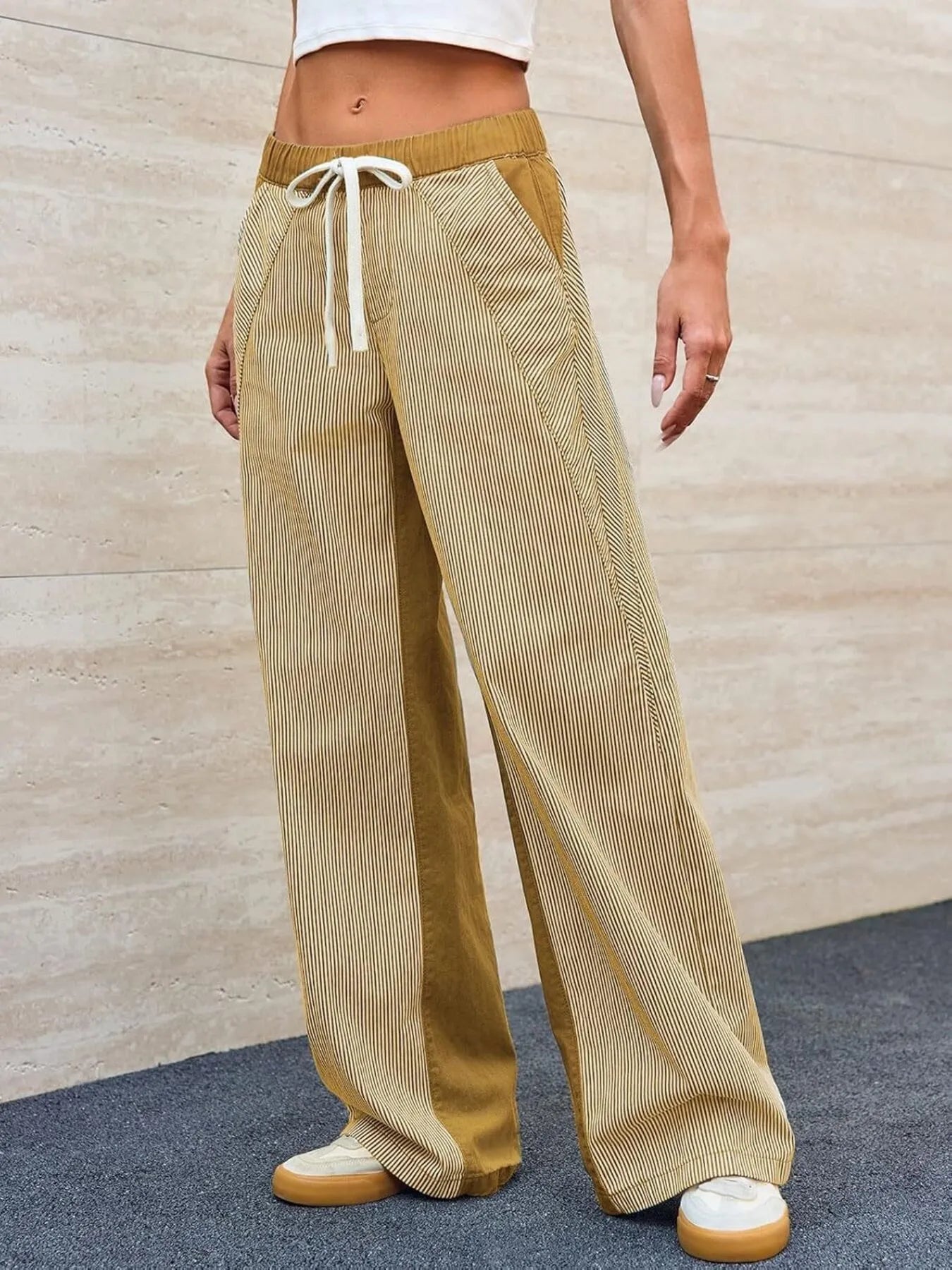Person wearing mustard yellow wide-leg pants with a white background