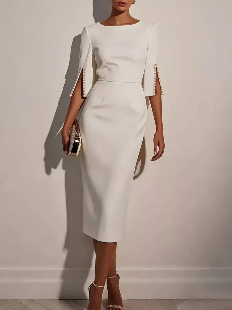 White dress with embellished sleeves on a plain background