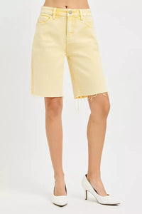 Light yellow denim shorts worn by a person on a white background