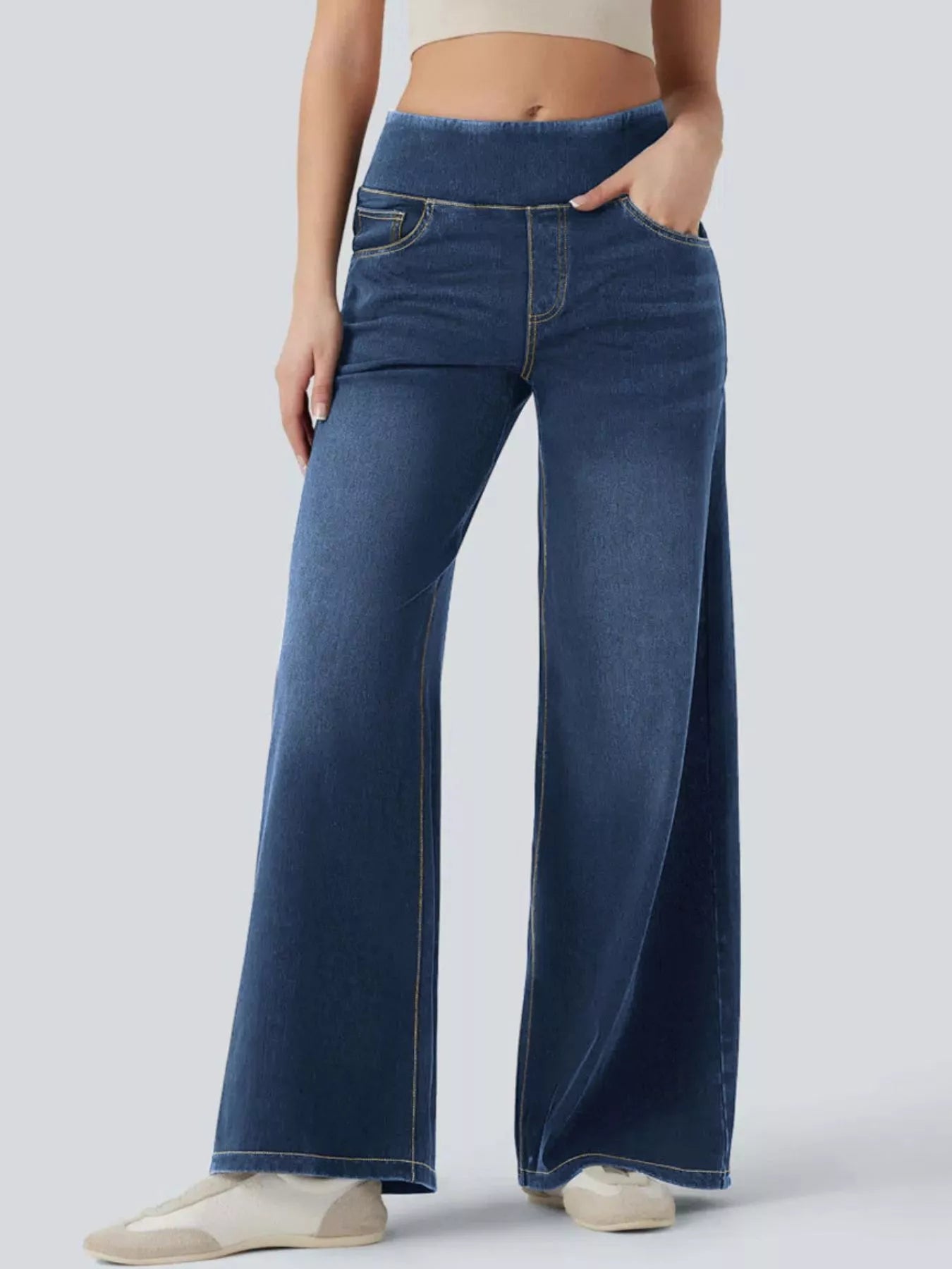 Person wearing blue wide-leg jeans on a white background