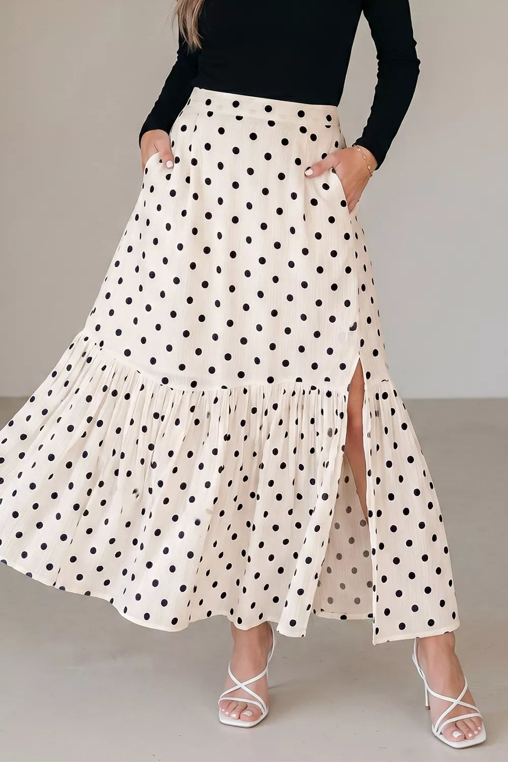 Woman wearing a polka dot skirt with a plain background