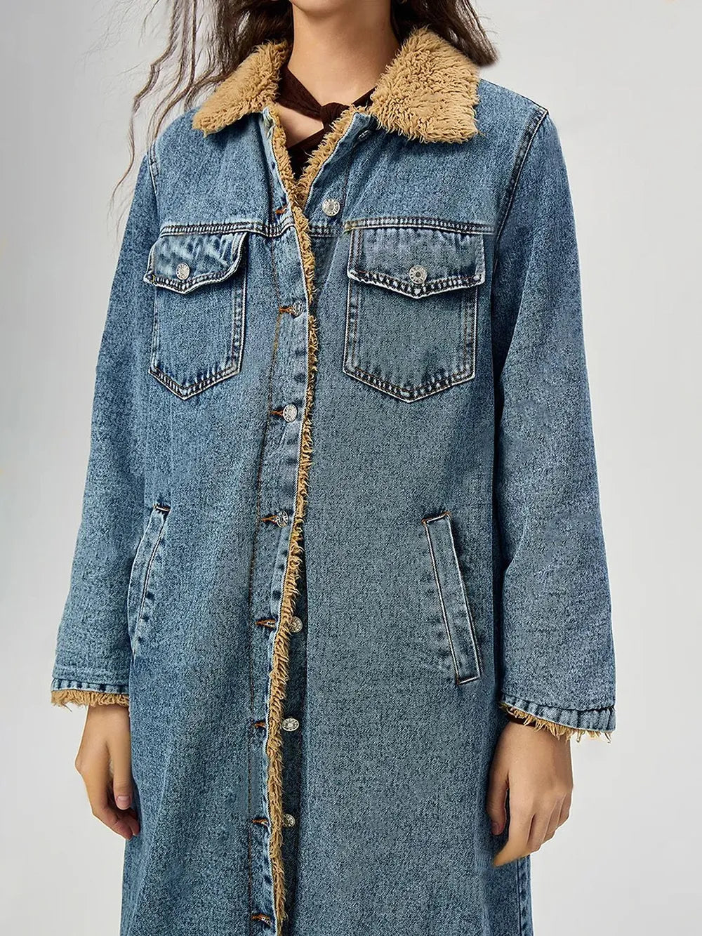 Denim coat with beige sherpa lining on a plain background