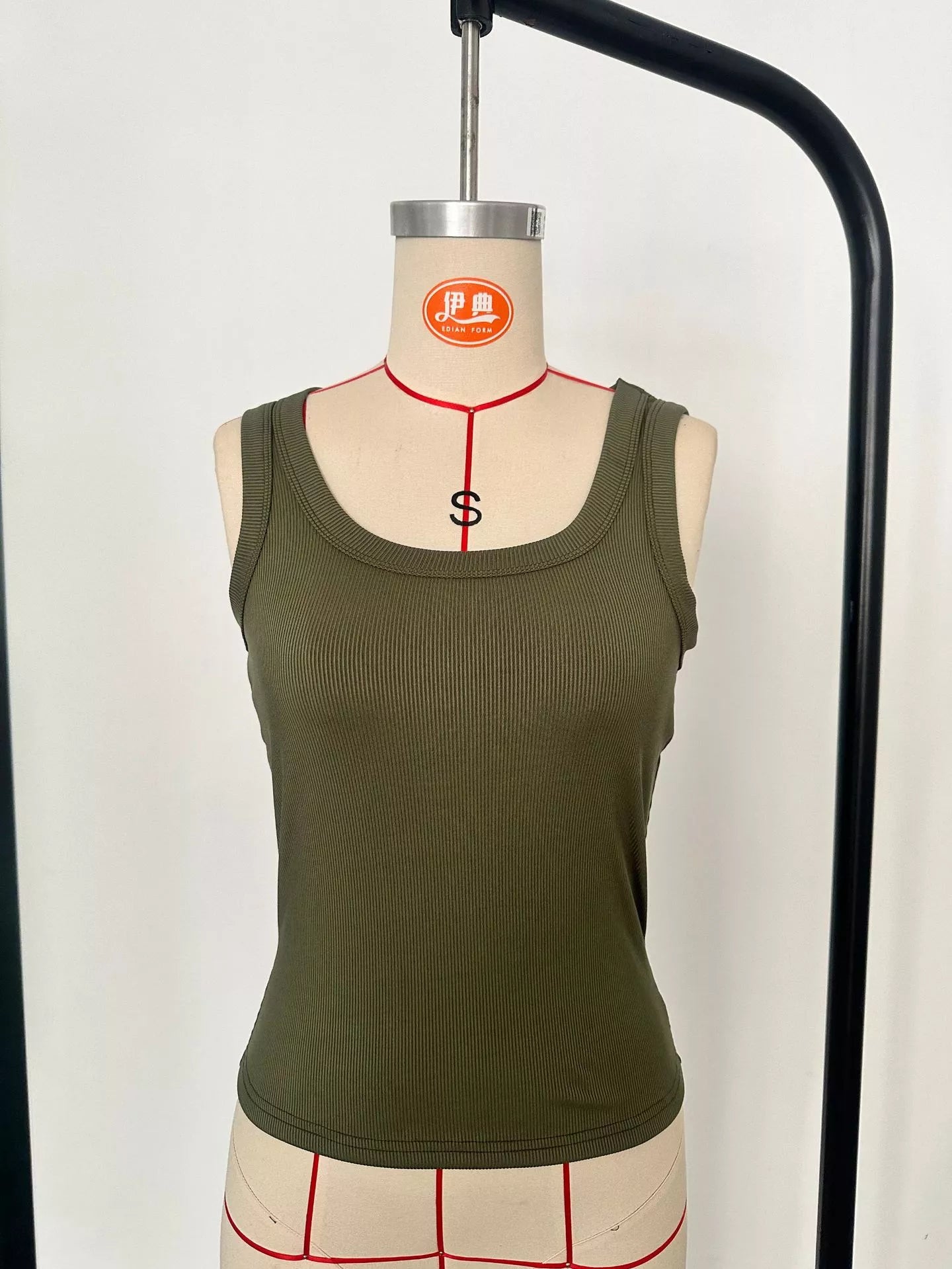Green tank top on a mannequin with a white background