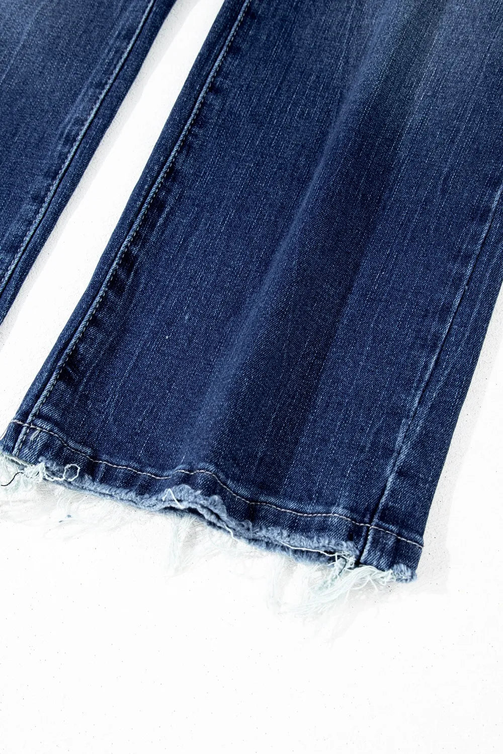 Close-up of blue jeans with lace trim on a white background