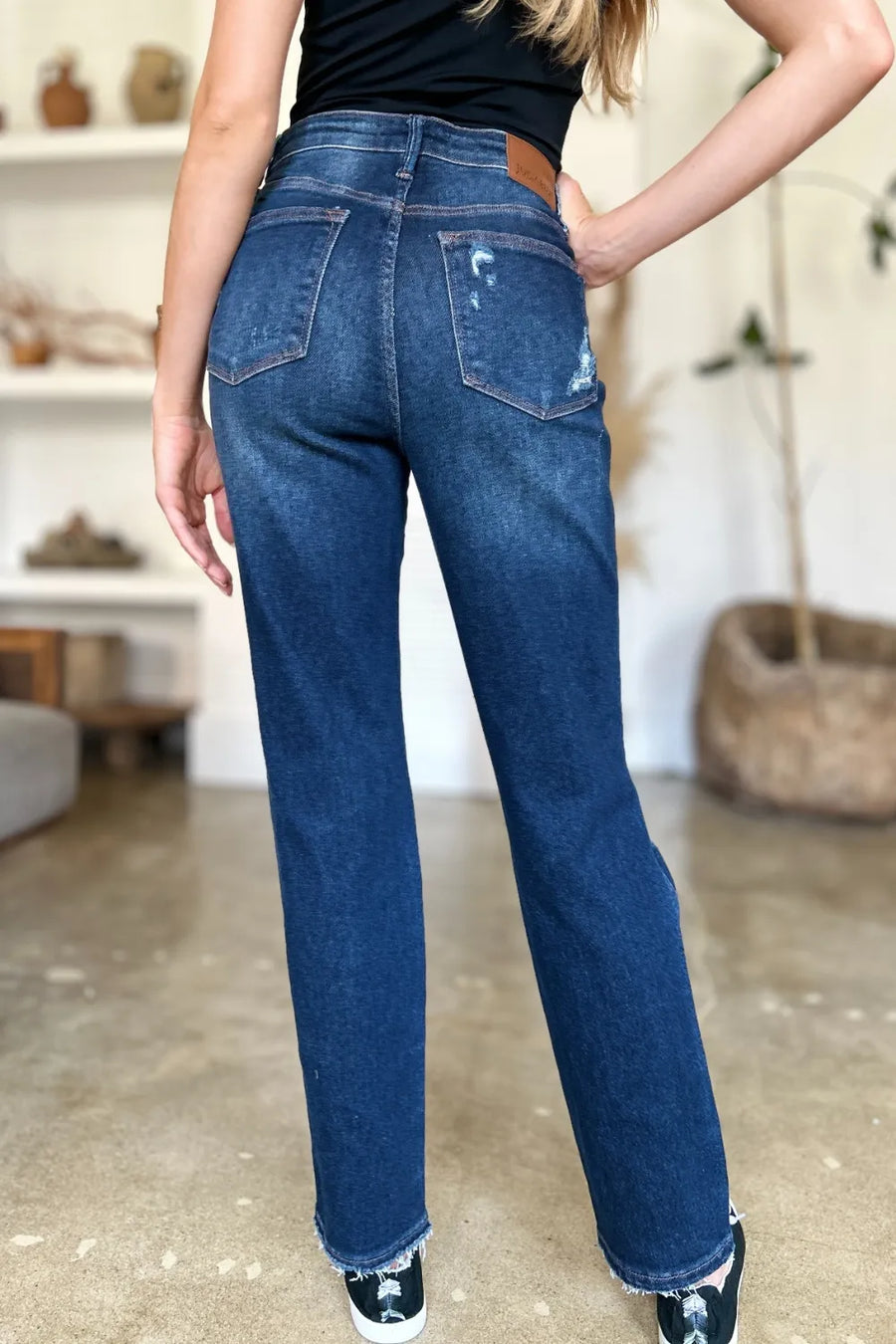 Person wearing blue jeans with a blurred indoor background
