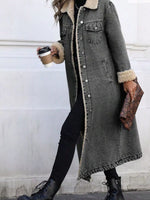Person wearing a long gray coat with fur trim, holding a coffee cup and clutch.