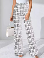 Person wearing black and white plaid pants holding a white handbag on a light gray background