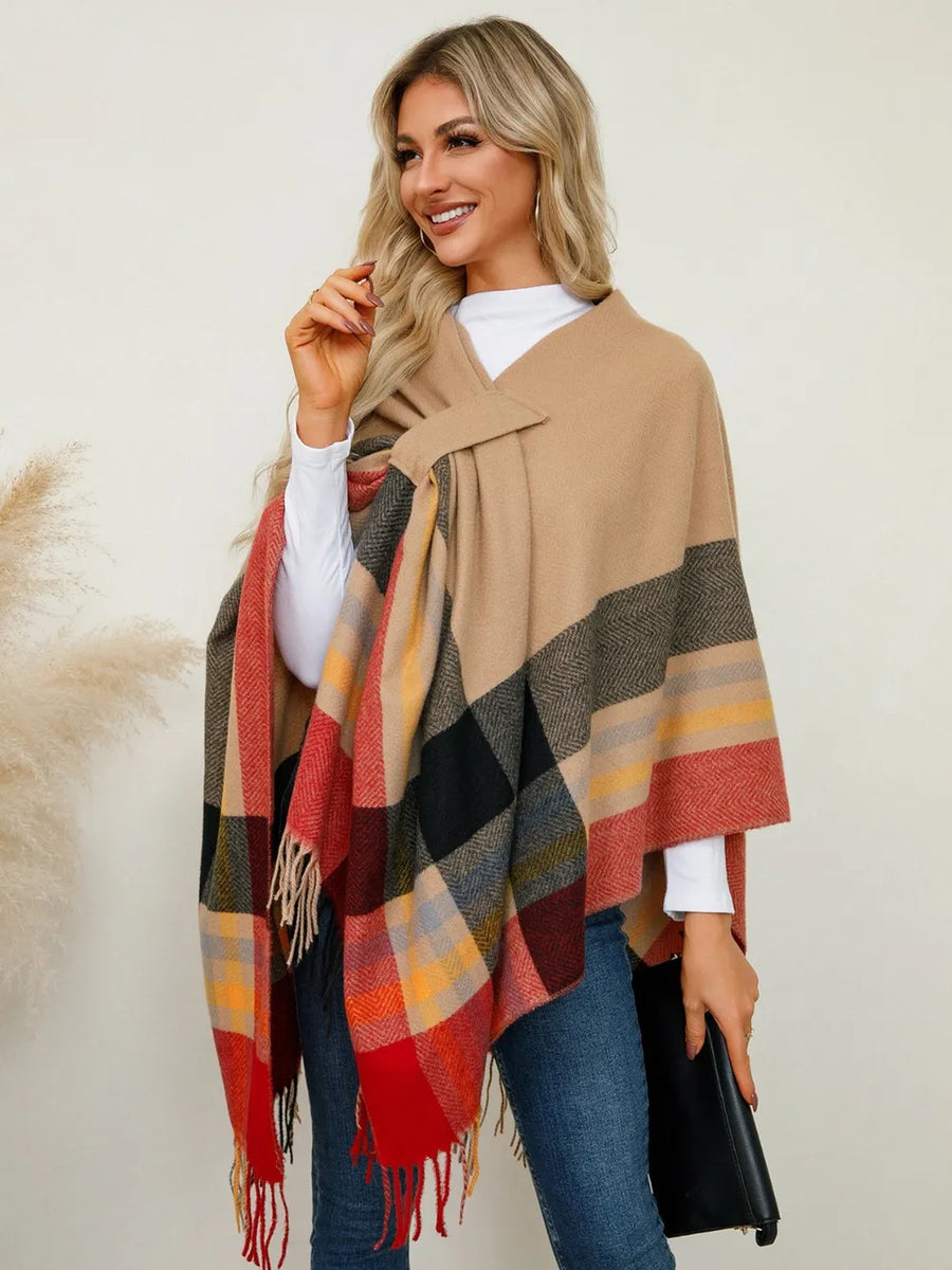 Woman wearing a plaid poncho with a neutral background