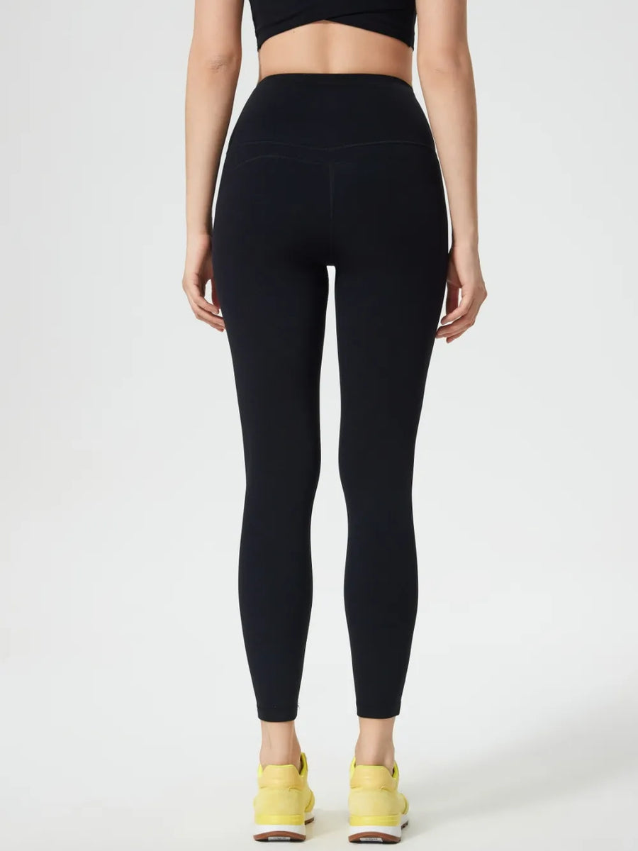 Person wearing black leggings and yellow sneakers on a white background