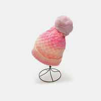 Pink beanie with a pom-pom on a white background