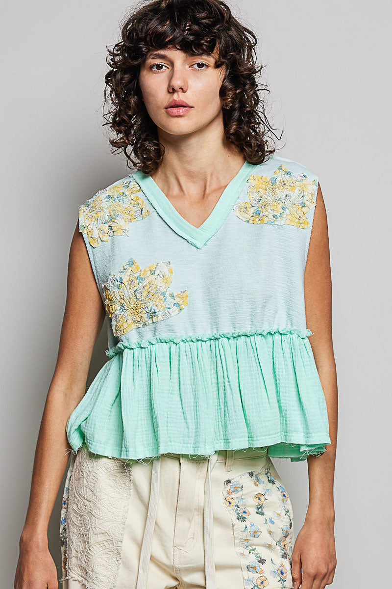 Woman wearing a light blue floral top against a plain background