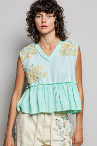 Woman wearing a light blue floral top against a plain background