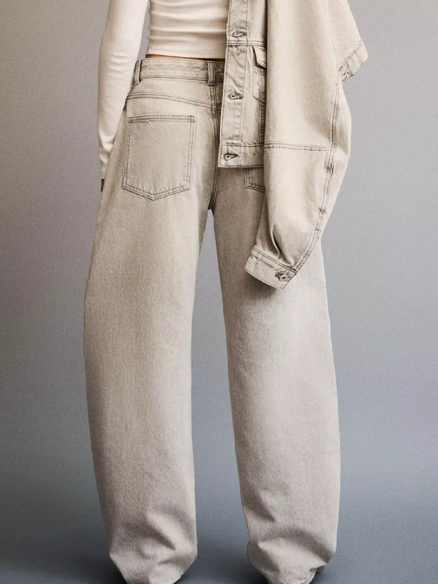Light-colored jeans worn by a person on a gray background