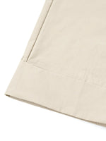 Close-up of beige fabric with a subtle pattern on a white background