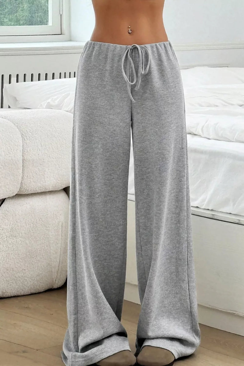 Person wearing gray lounge pants in a living room setting
