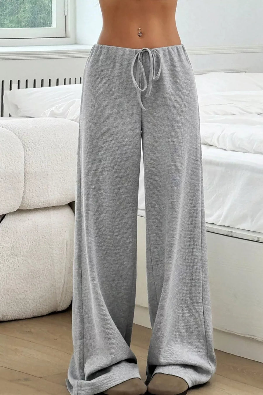 Person wearing gray lounge pants in a living room setting